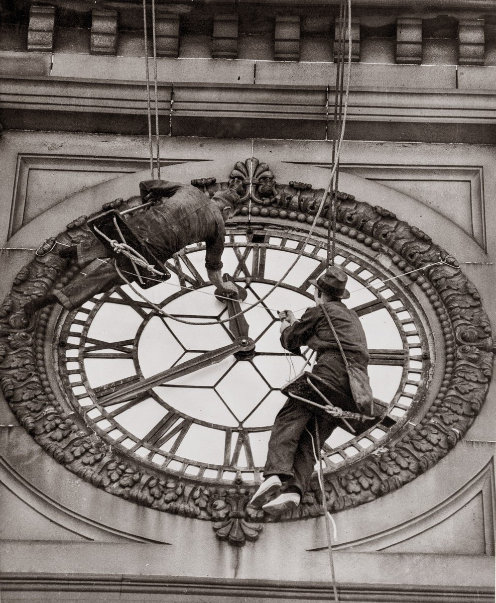 Cleaning the clock face of Sydney Town Hall, George Street Sydney, 1937, Sydney city centre