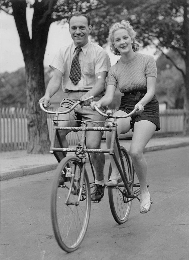 Man and woman on a Malvern Star abreast tandem bicycle, c. 1930s, by Sam Hood