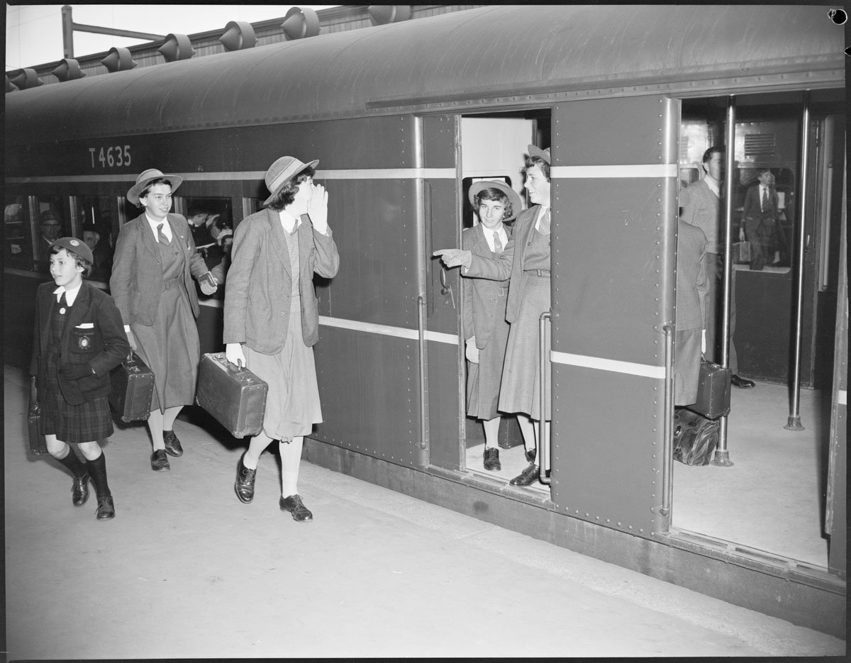 Safety first photos. School girls calling to one another as train moves out of station, Sydney (c. 1958)