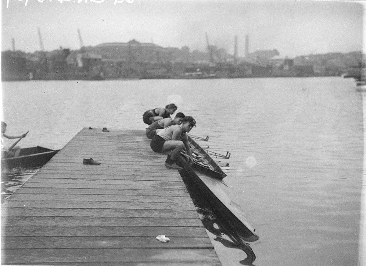 A fours crew lowering their shell into the water (c. 1935)