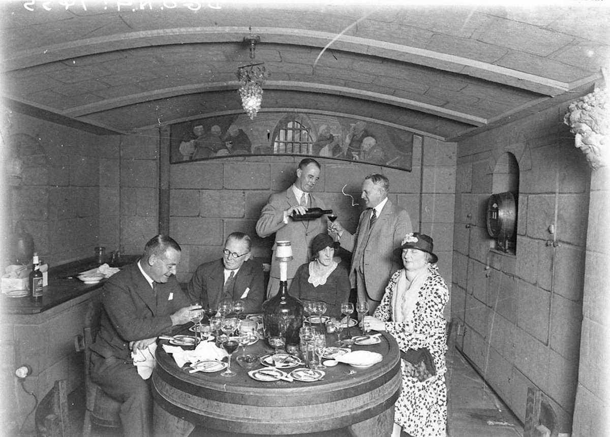 A client pouring wine for Leo Buring right background (1930s)