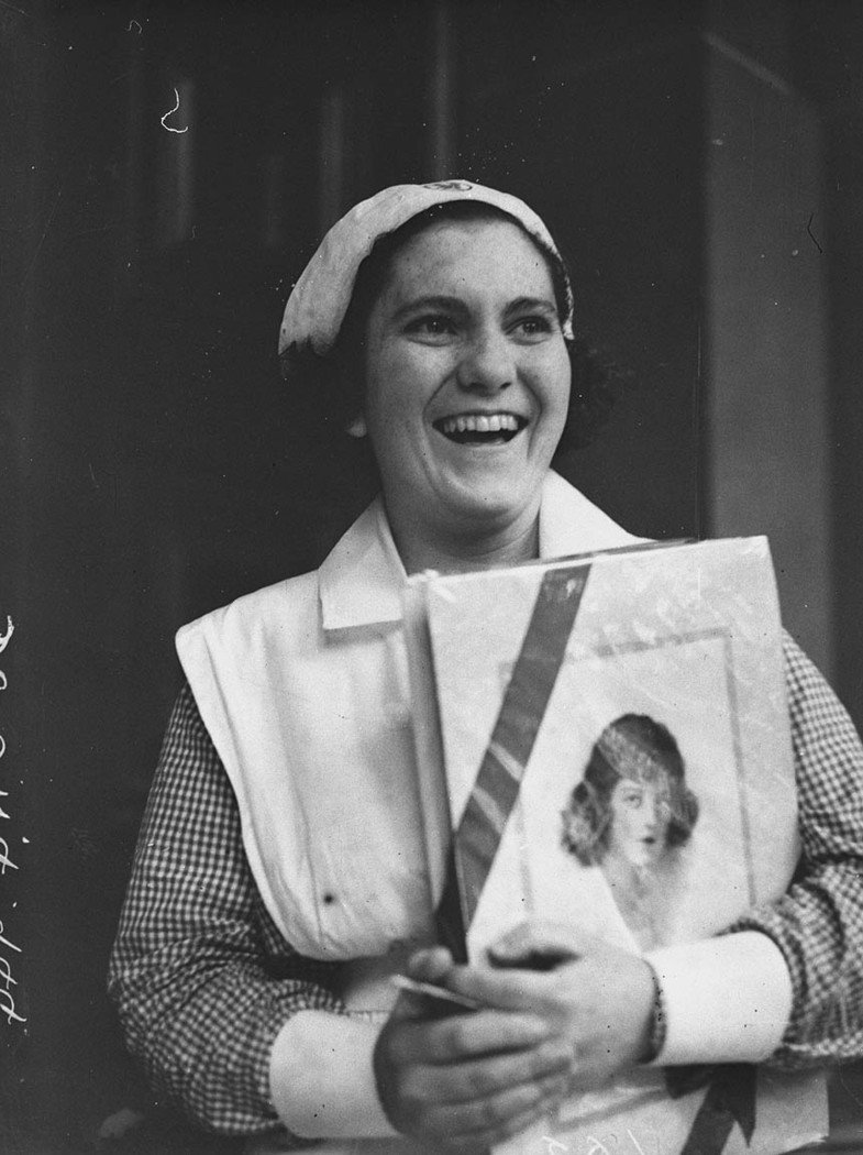 A girl prizewinner with her box of chocolates (1920s)