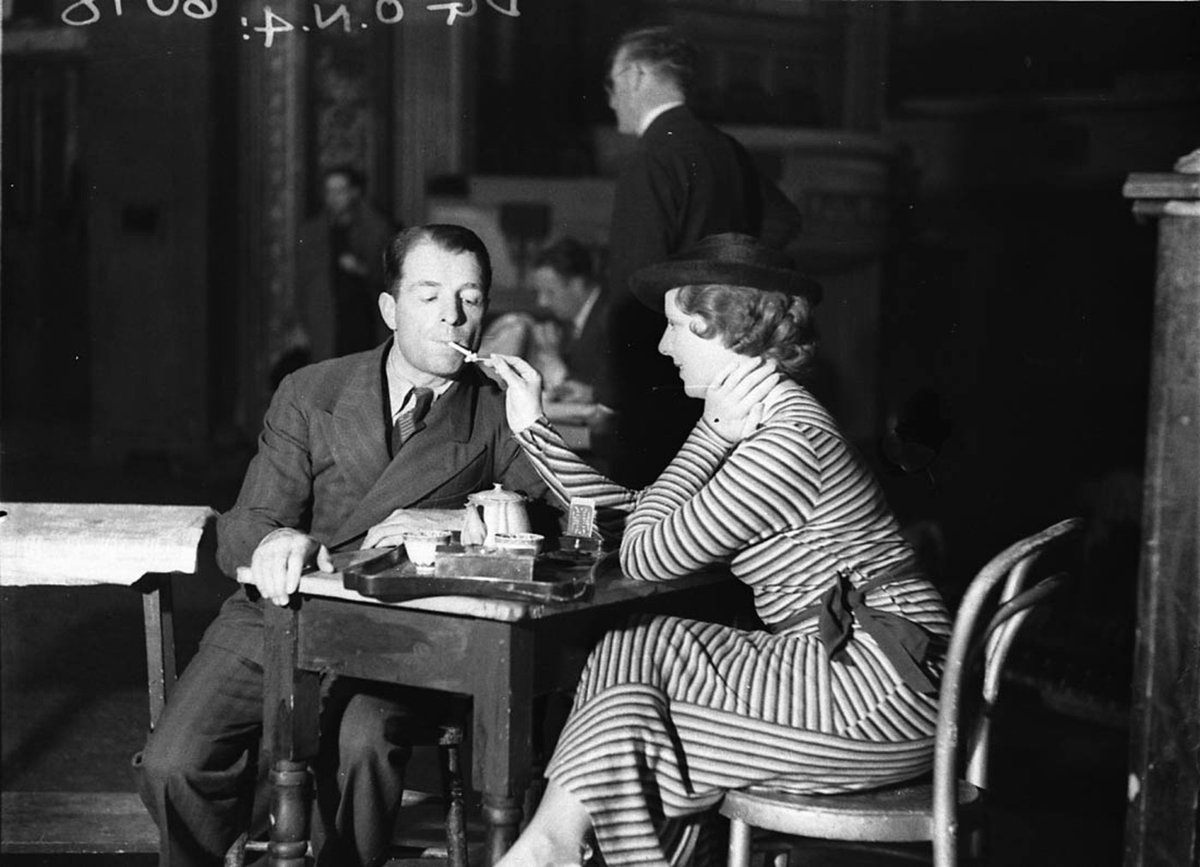 Actress lights actors cigarette during tea break in rehearsals for Viktoria and her hussar (c. 1935)