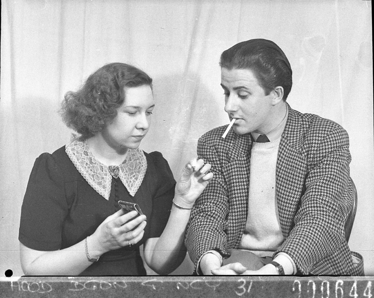An actress lighting an actors cigarette scene from These Children BritishAustralian production (1944)