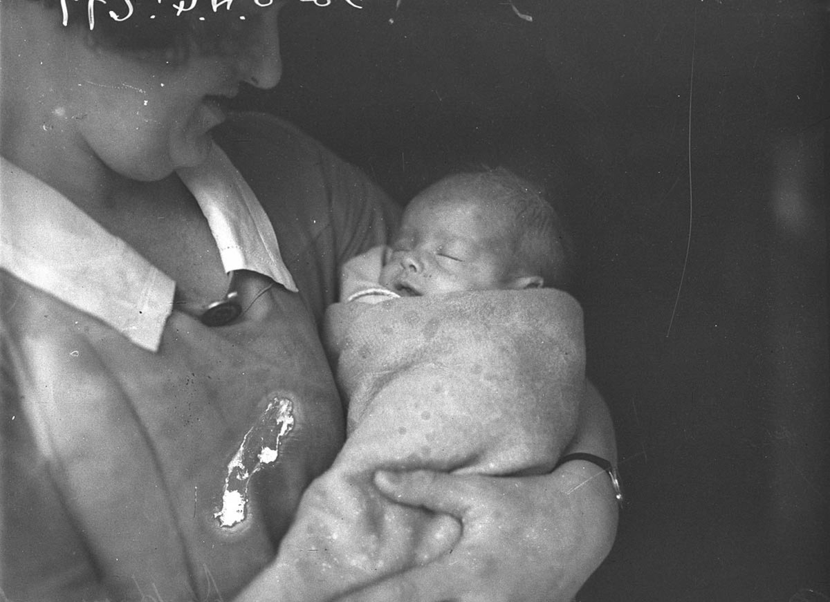Baby John Haywood in the arms of a nurse (1934)