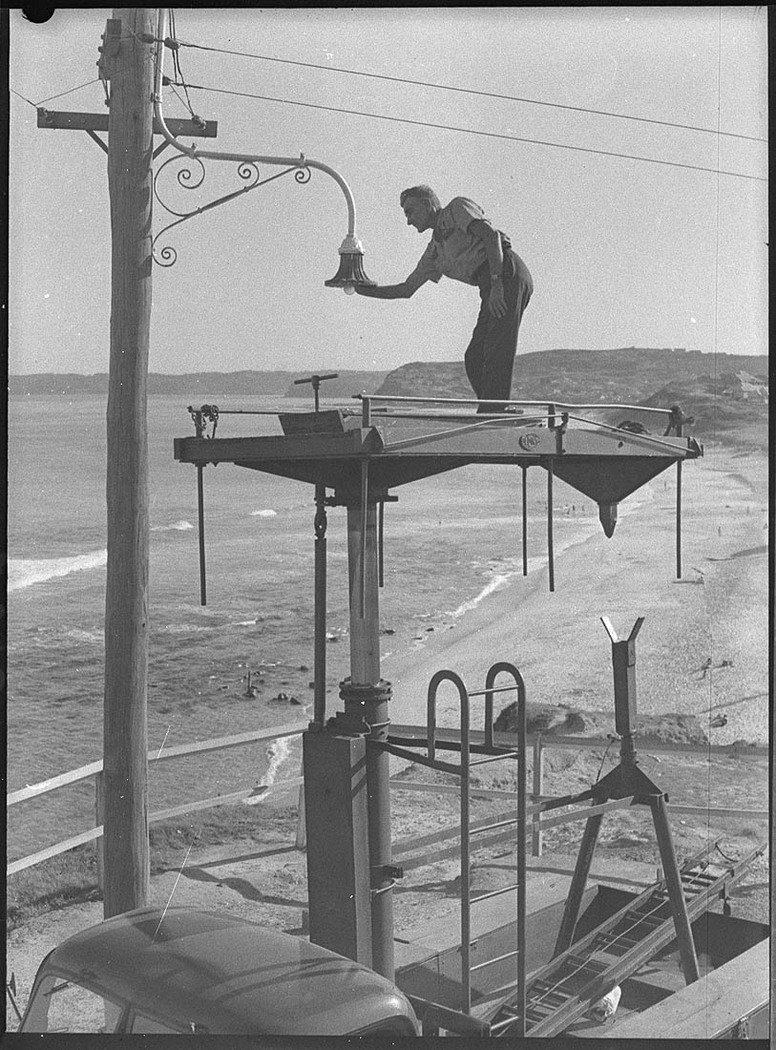 Cleaning street lamps by Nesca Bar Beach adjustable platform on truck (1954)