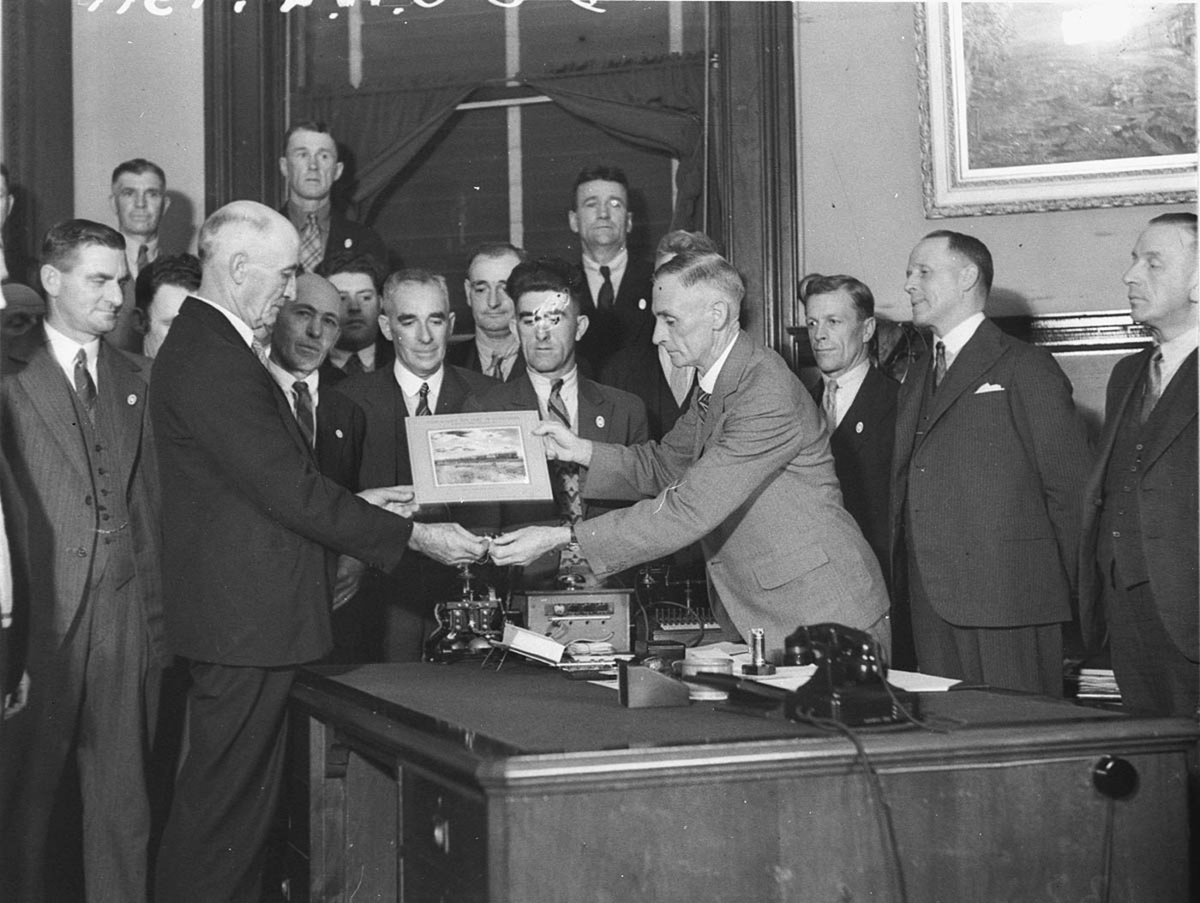 Commissioner for Railways Mr Hartigan presents workers on the Royal Train with a photograph of the train (1934)