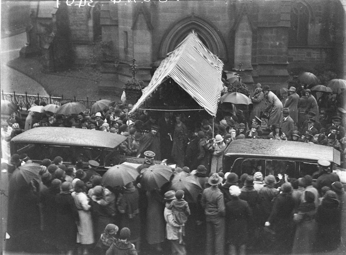 Crowds wait in rain to see WhitneyFriend bridal couple leave St Johns Church (1934)