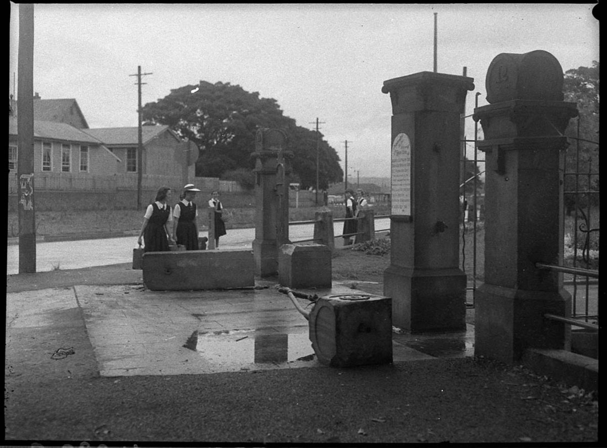 Damaged gates at entrance to Gregson Park Hamilton Hamilton school in background (1955)