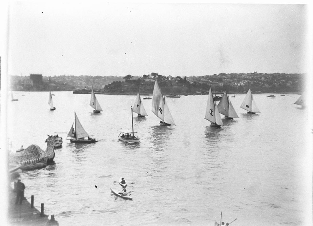 Eighteen footers sail past the Sea Dragon (c. 1934)