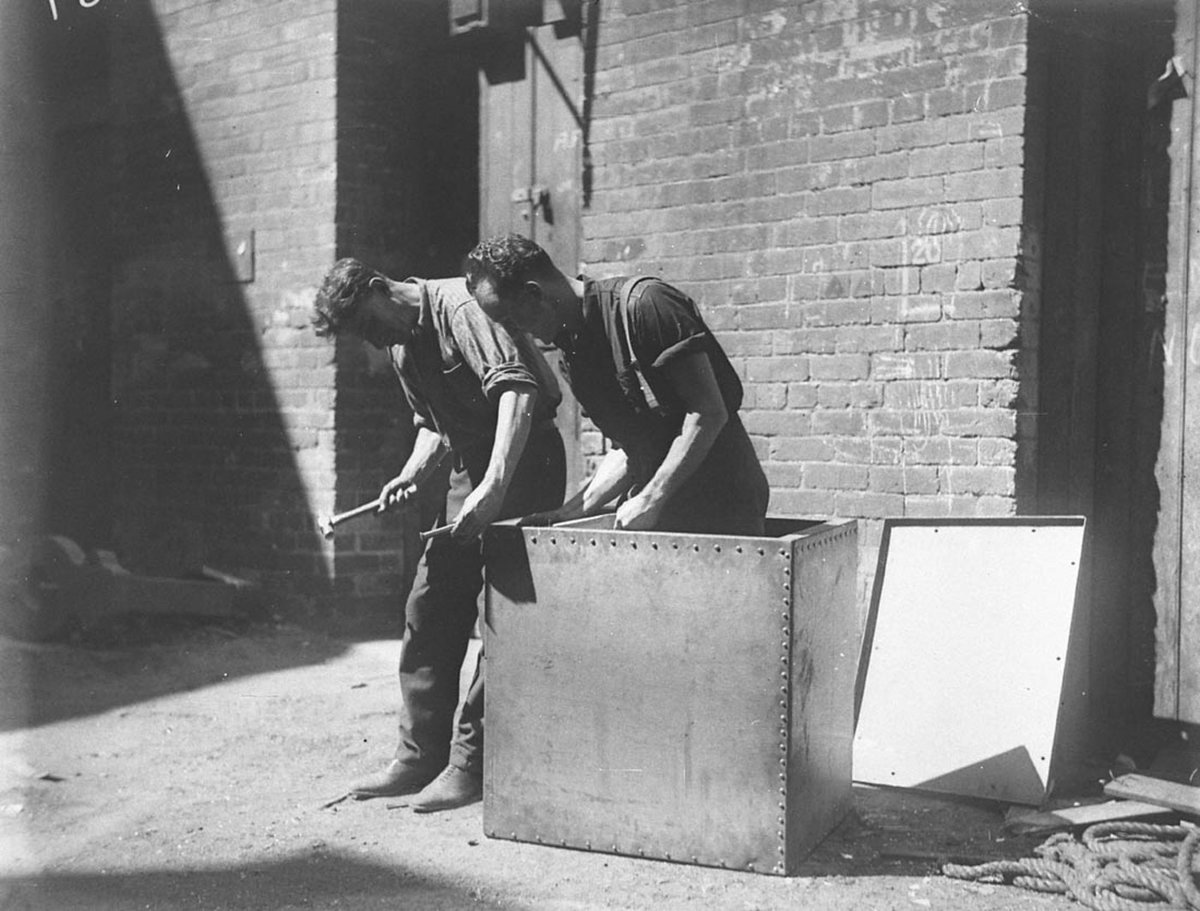 Fitters rivet the airtight box from which Murray the Escapologist proposes to escape in a Tivoli show, Sydney city centre (1928)