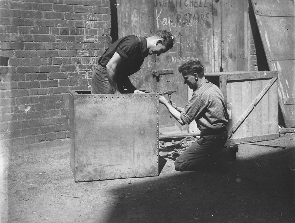 Fitters rivetting an airtight box from which Murray the Escapologist was to make his escape in a Tivoli show, Sydney city centre (1928)