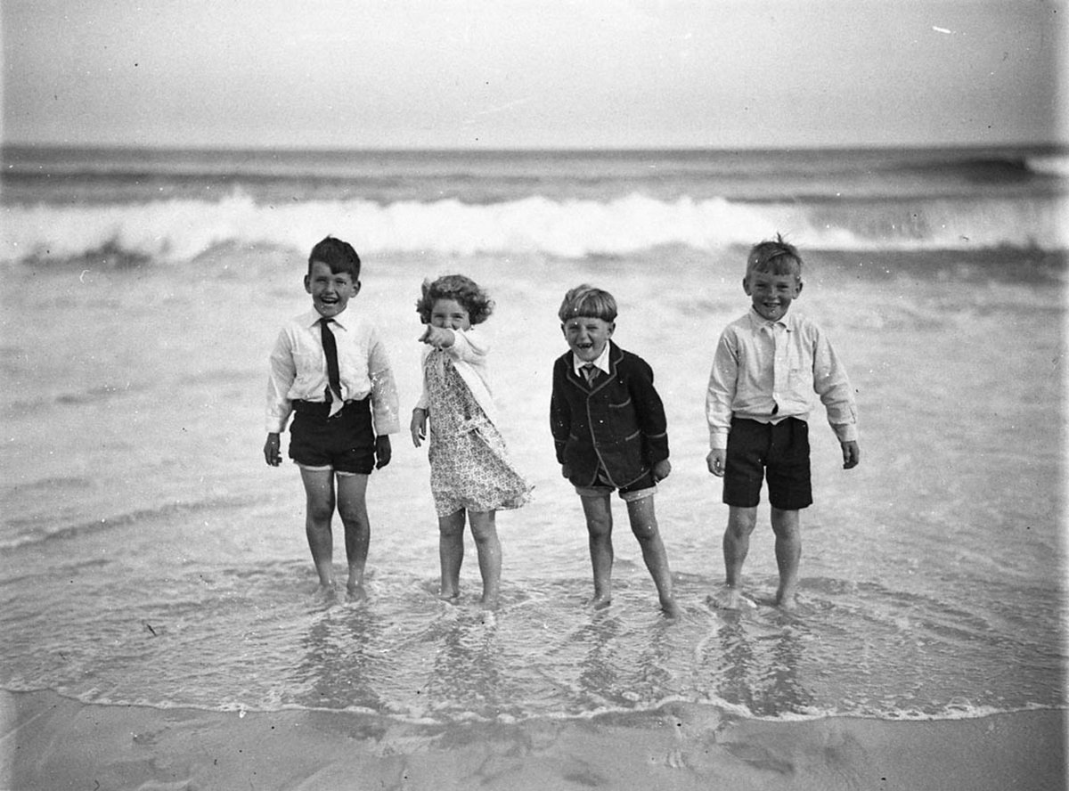 Four young children paddling fully clothed (1932)