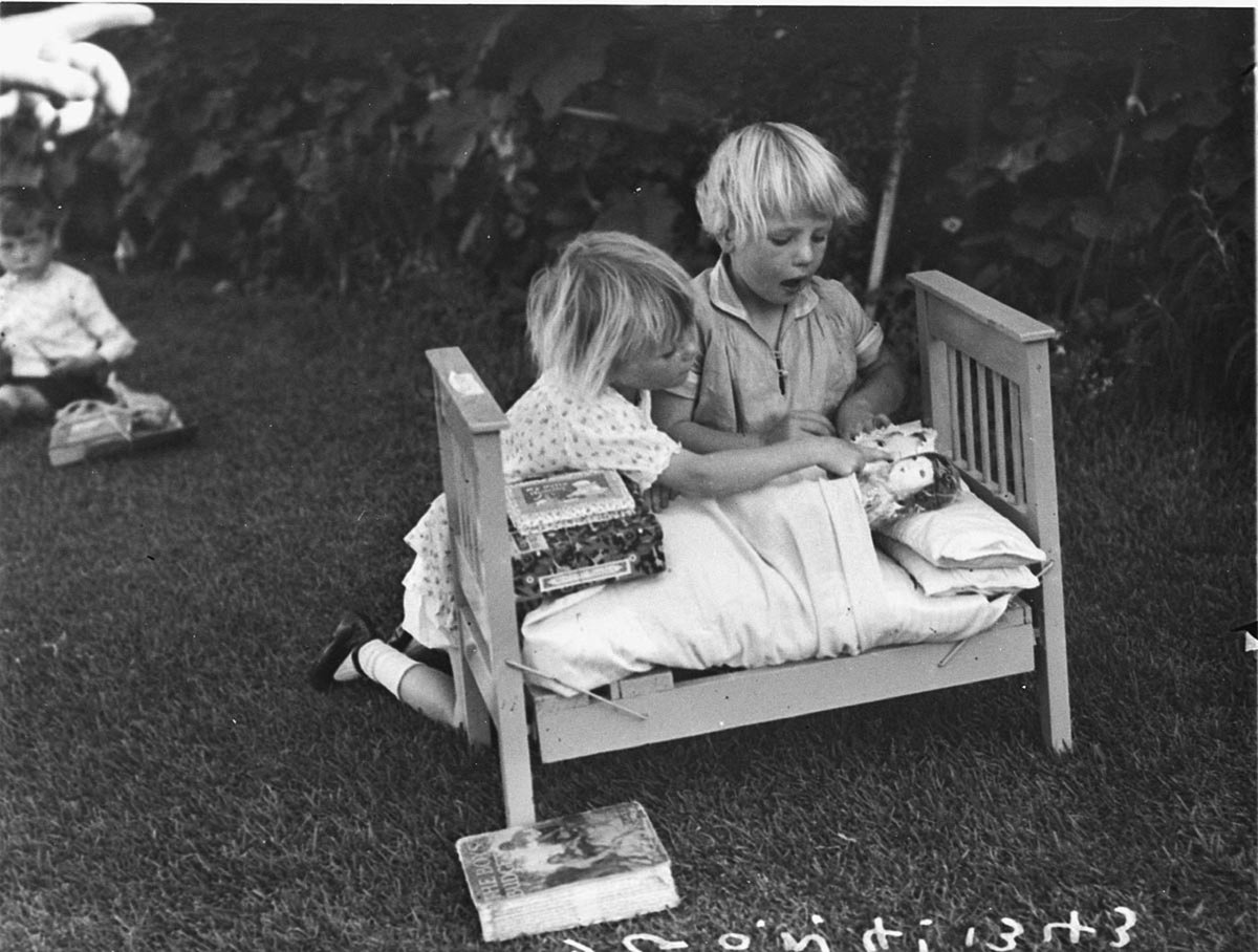 Girls playing with doll and bed at the Christmas party St Anthonys House Croydon (1934)