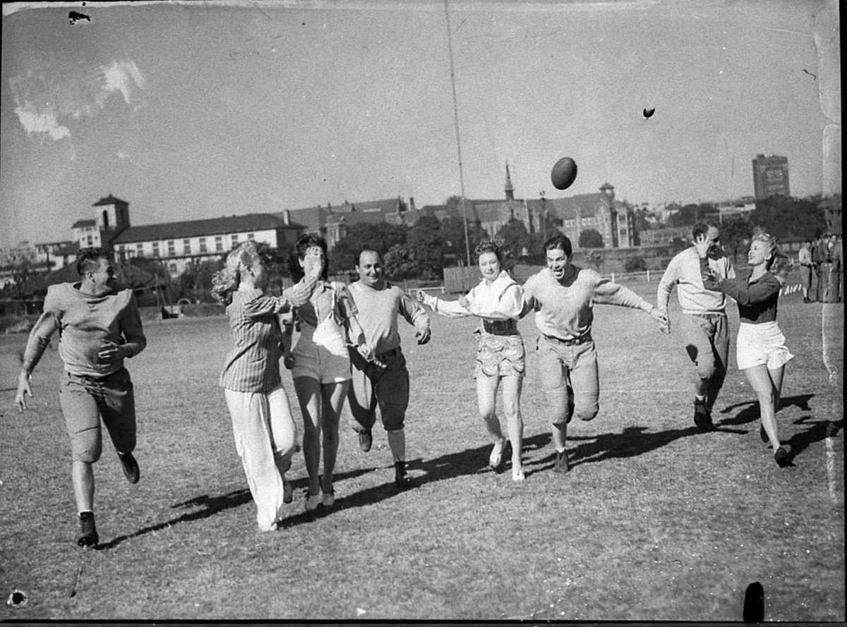 Grid iron players with Tivoli girls, Sydney city centre (1956)