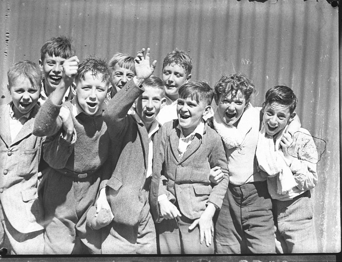Group of schoolboys cheering at swimming caarnival (1935)