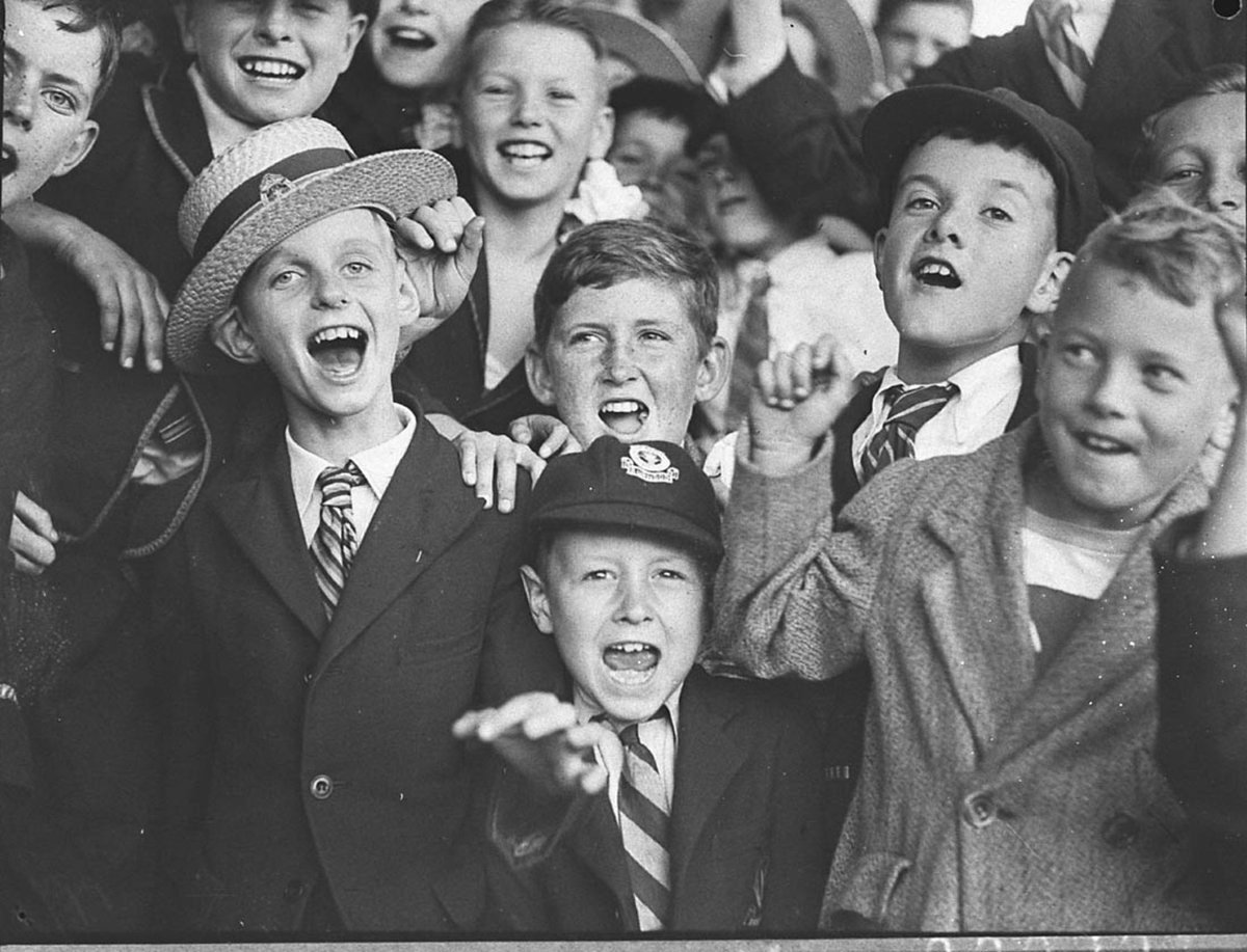 Group of schoolboys cheering at swimming carnival (1935)
