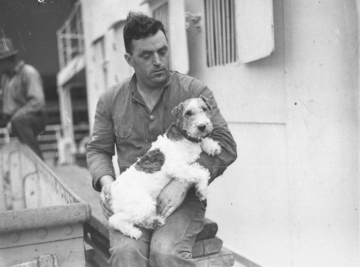Man holding a shaggyhaired terrier (c. 1935)