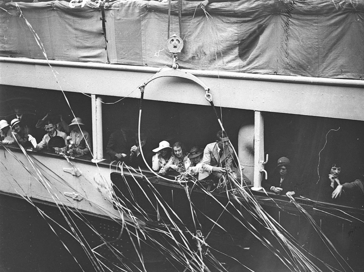Mass of streamers as passenger ship leaves the wharf (1930s)