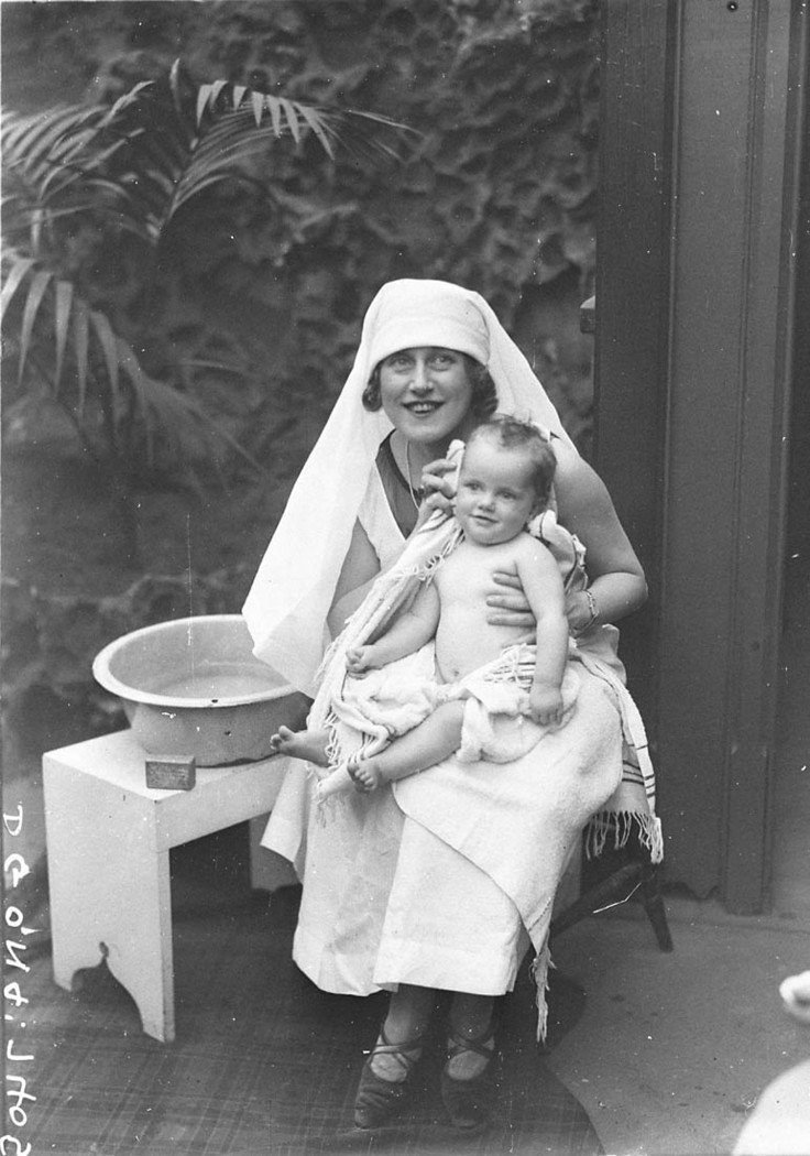 Musical comedy star Dorothy Brunton washing a baby (1925)