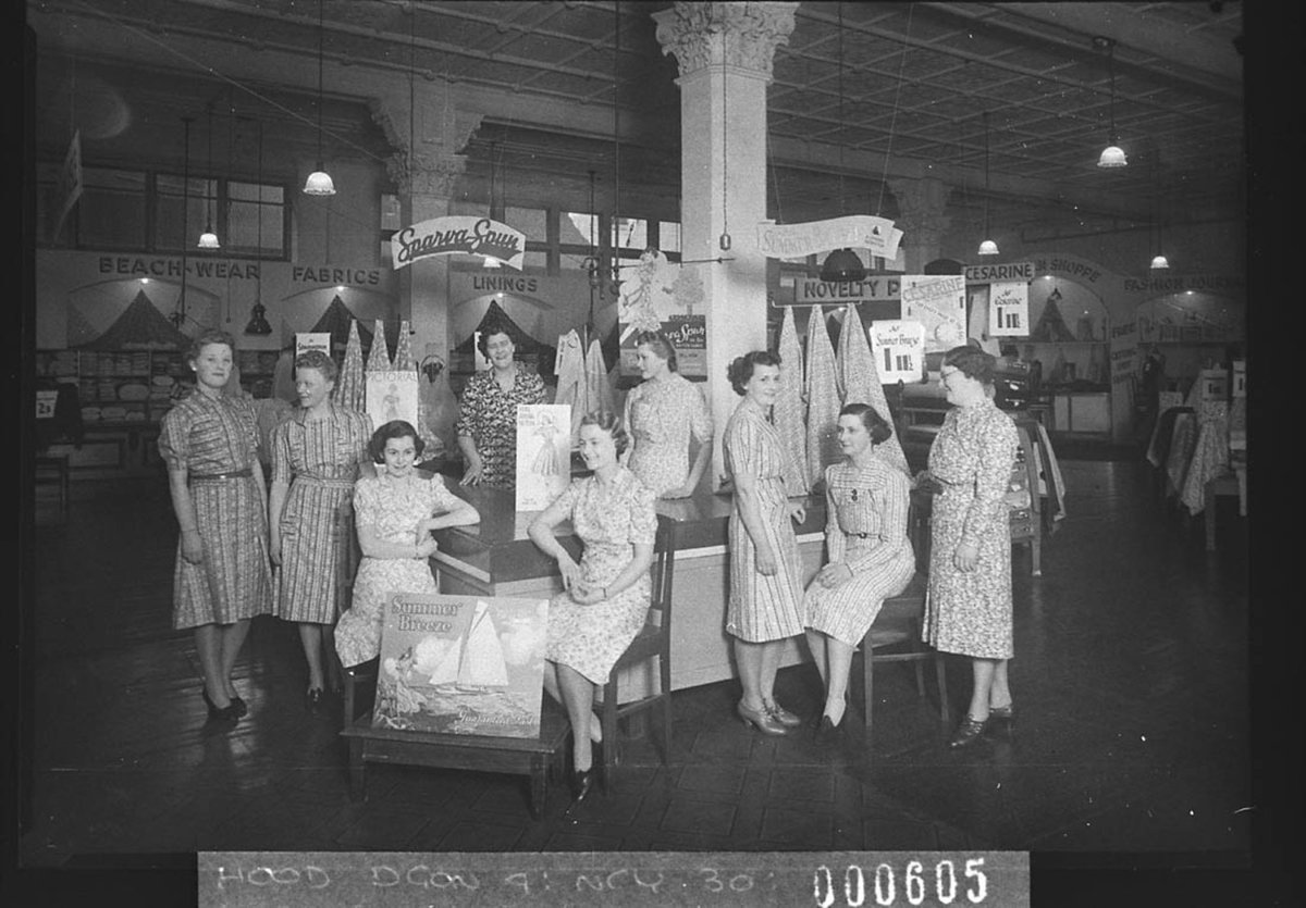 Nine salesgirls in front of Cesarine fabrics and SparvaSpun Lining, Sydney (1939)