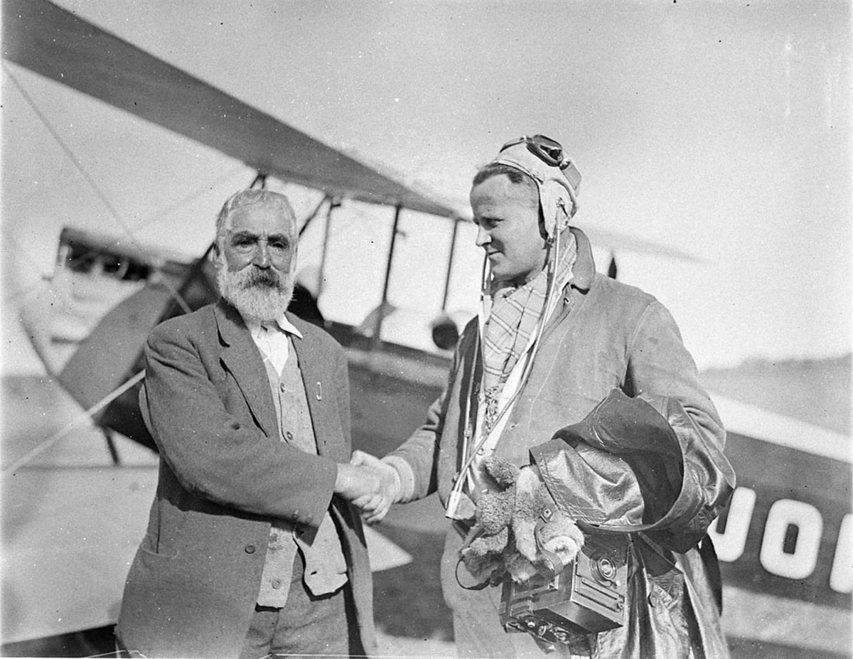 Pilot of Gypsy Moth VHUOP shaking hands with bearded passenger (1930s)