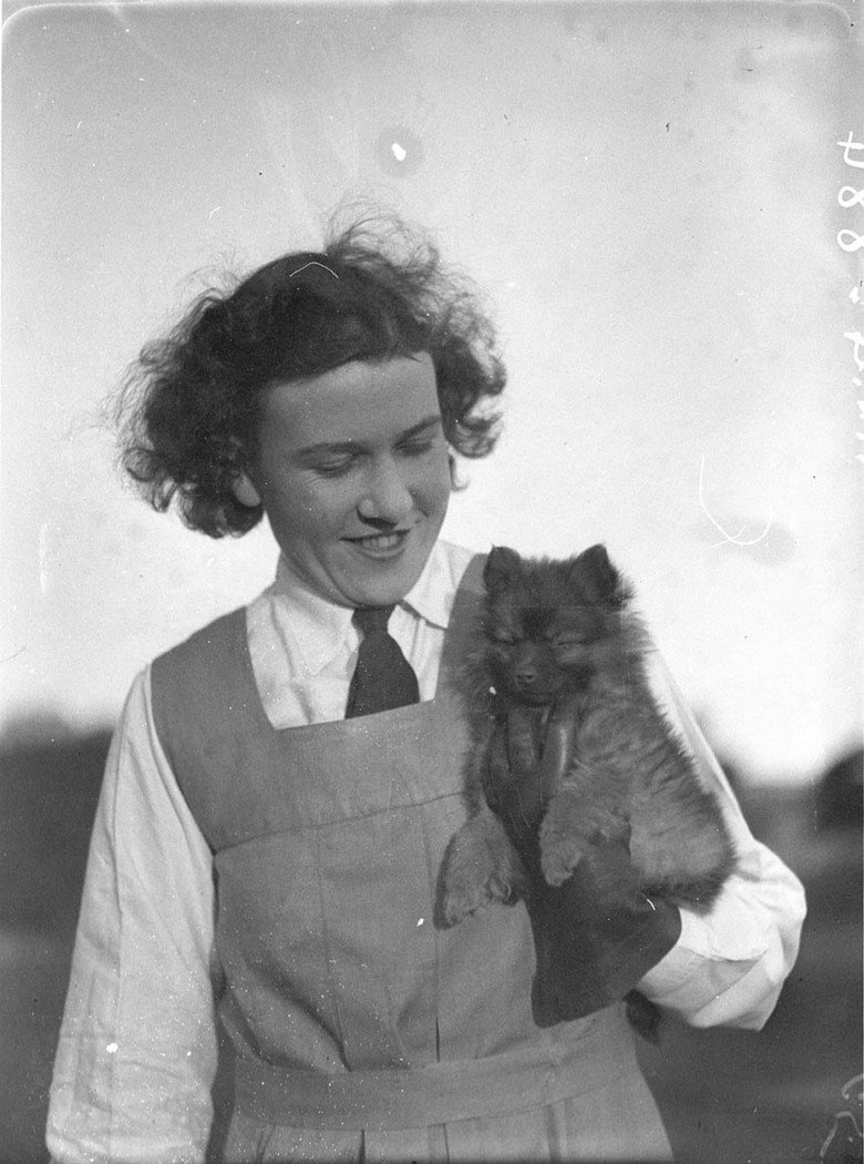 Schoolgirl holding a puppy (1930s)