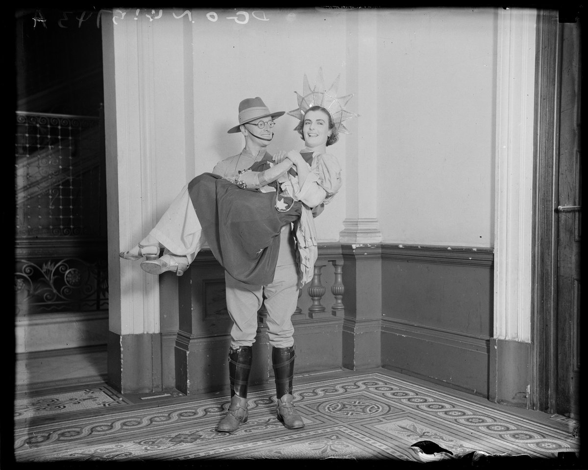 Soldier holding up a girl in fancy dress costume as Australia (c. 1932)