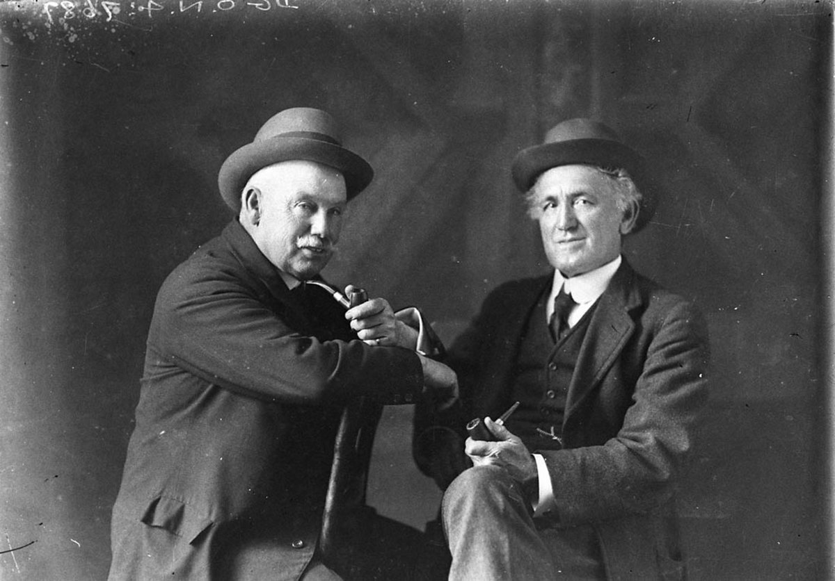Studio portrait of two men with pipes and hats on (1930s)