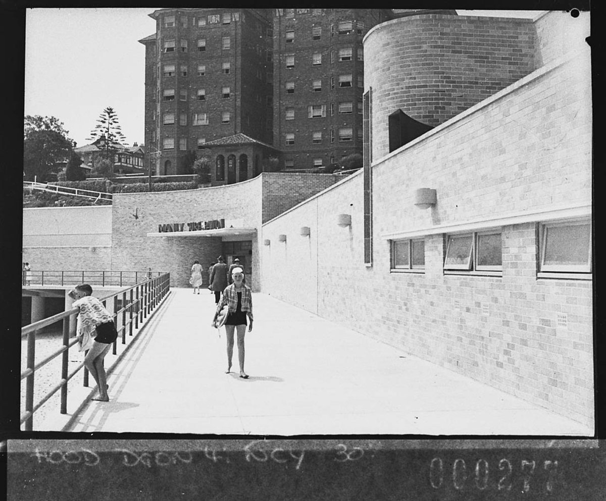 Surfer strolling down the promenade for Building Publishing Co, Manly (1939)