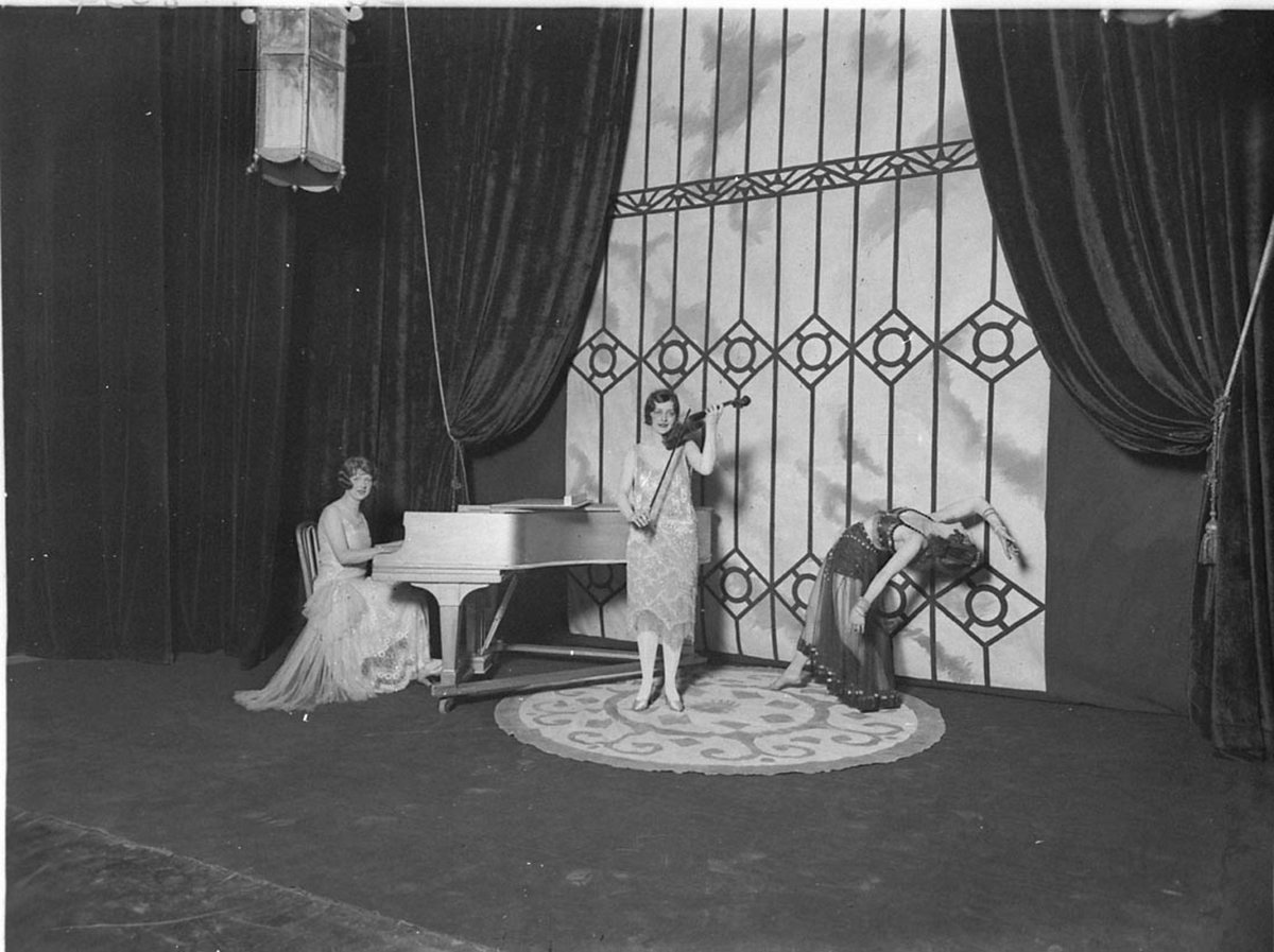 Three women entertainers on stage pianist violinist and dancer (1930s)