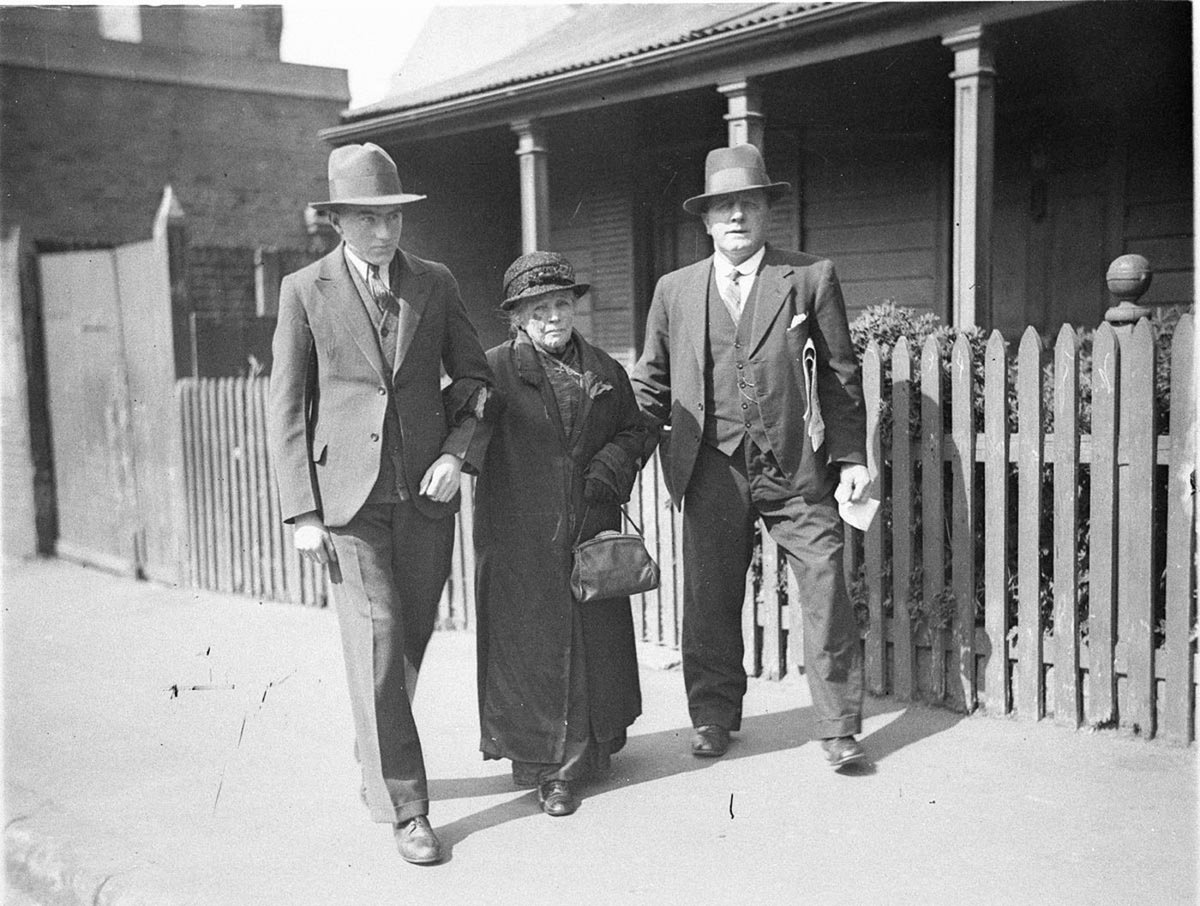 Two ALP supporters assisting an old woman voter to the polling booth (c. 1934)
