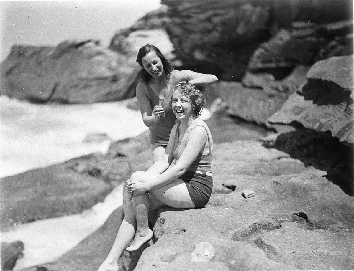 Two Capitol Theatre chorus girls in swimsuits one combing the others hair after a swim, Haymarket (1933)