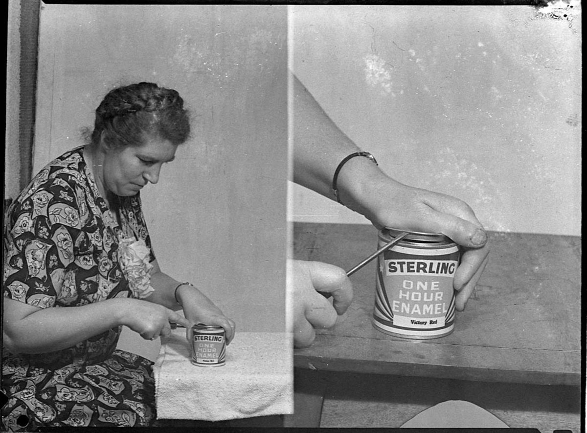 Woman opening a tin of Sterling Victory Red one hour enamel For Sterling Paints (1940s)