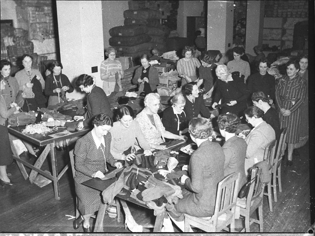 Women volunteer workers doing up clothing parcels at the ACF rooms taken for Australian Comforts Fund (1944)