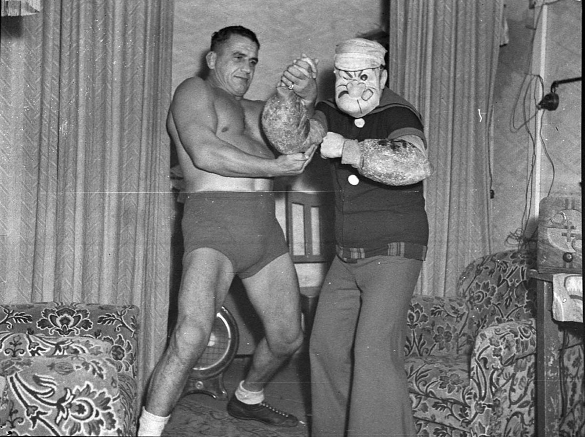 Wrestler Ray Steele and cartoon character Popeye at the Tivoli taken for Stadiums Ltd, Sydney city centre (1938)