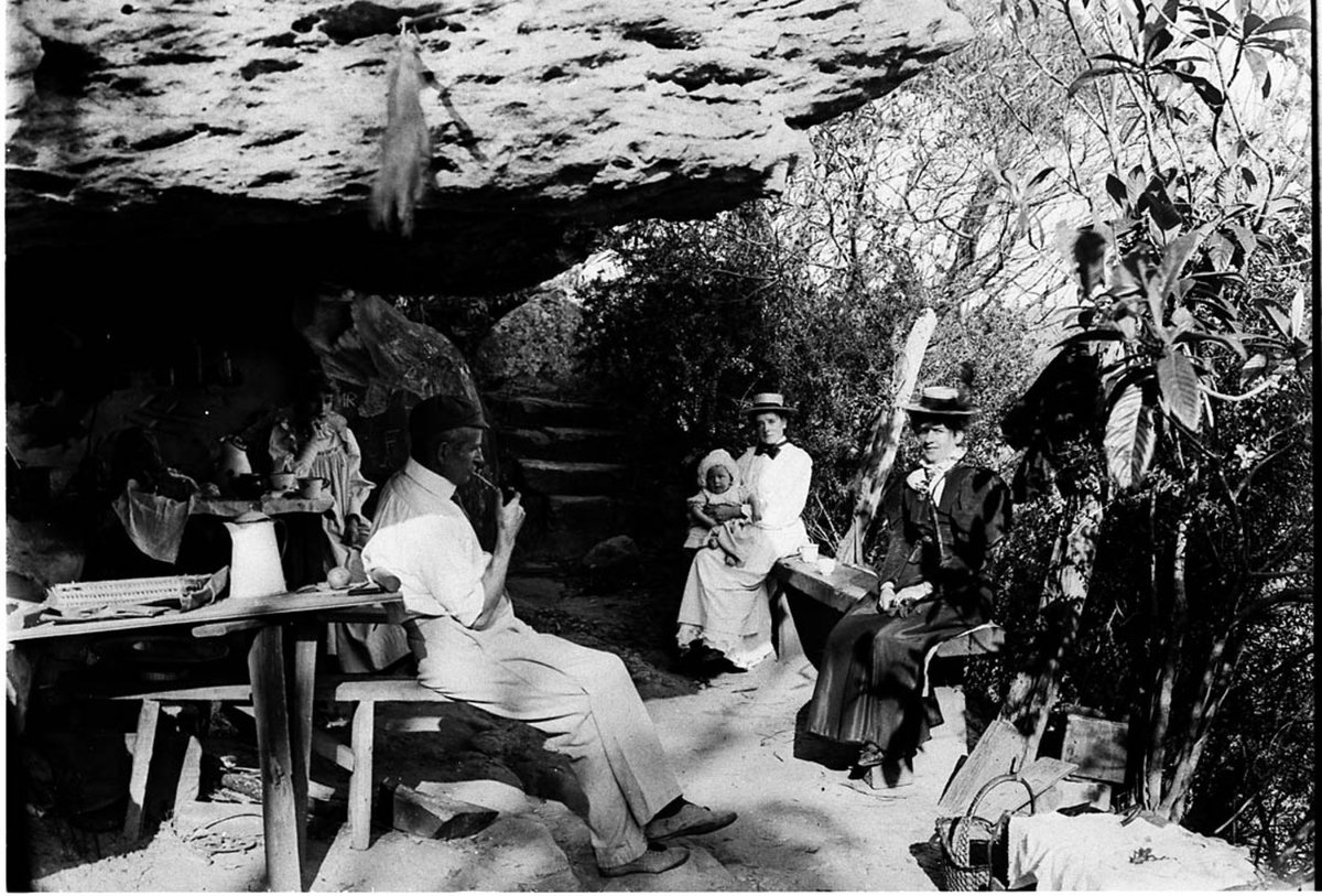 Perier family in kitchen of camp in rock shelter, Middle Harbour, c. 1900 by A.J. Perier, 1893, by A.J. Perier, Haymarket
