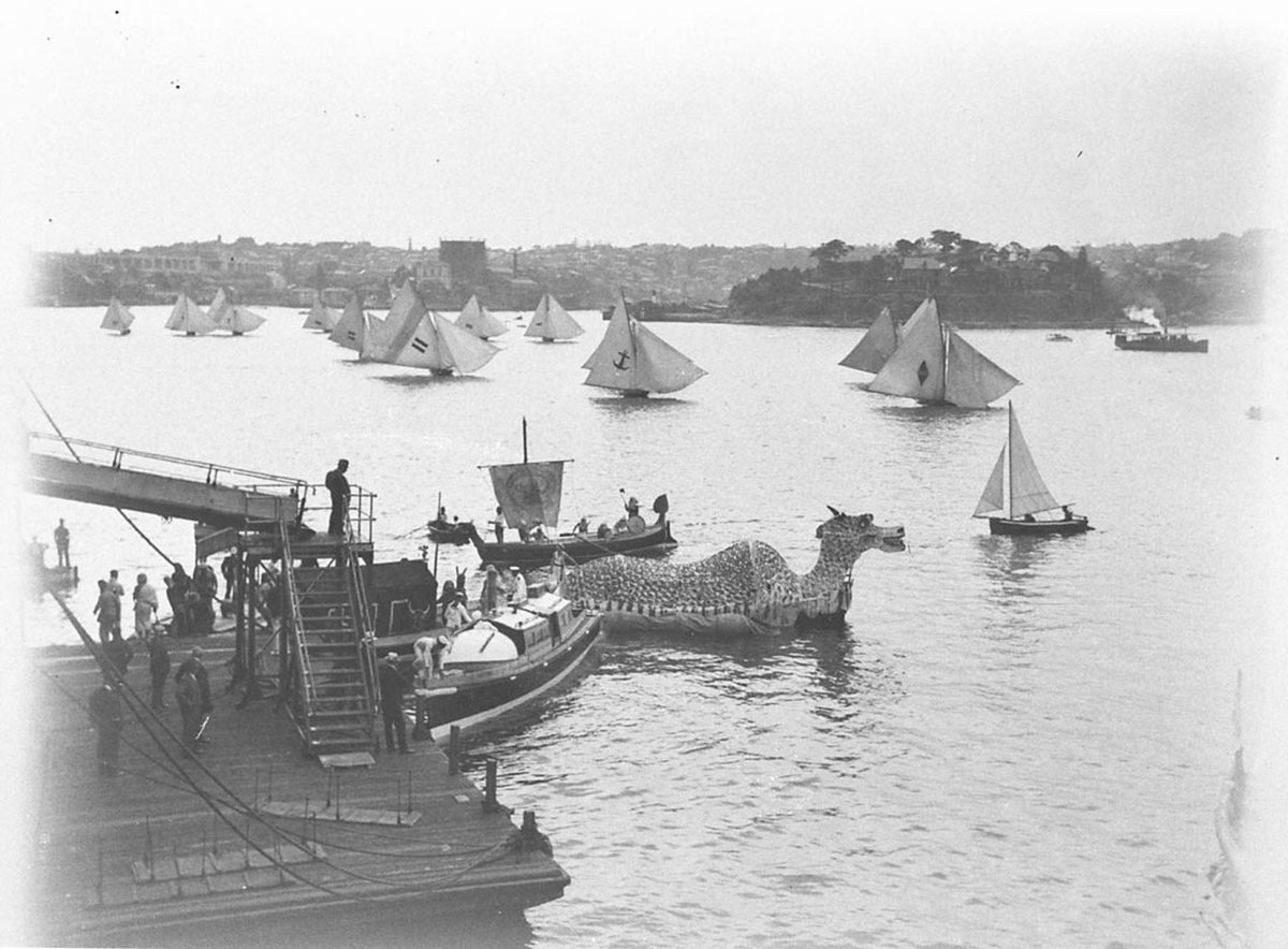 Eighteen footers sail past the 'Sea Dragon', c. 1934, by Sam Hood, Sydney