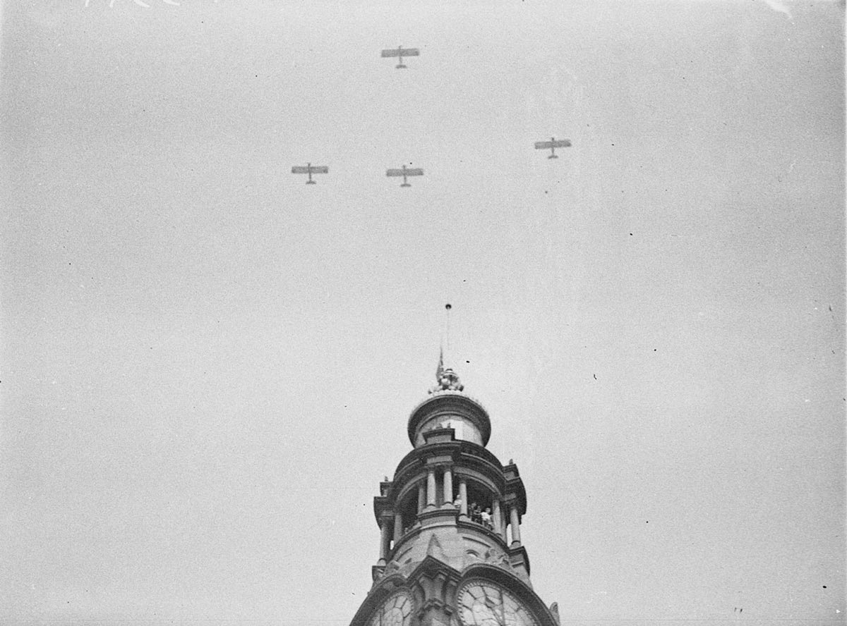 Five Westland Wapitis of No 3 Squadron, RAAF, fly past the GPO clock which shows "One-Minute's Silence", Armistice Day, 11am, 11 November 1934 - photographer Sam Hood, Sydney city centre