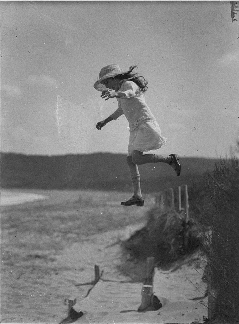 Unidentified small girl leaping onto the beach, c. 1930s, by Sam Hood