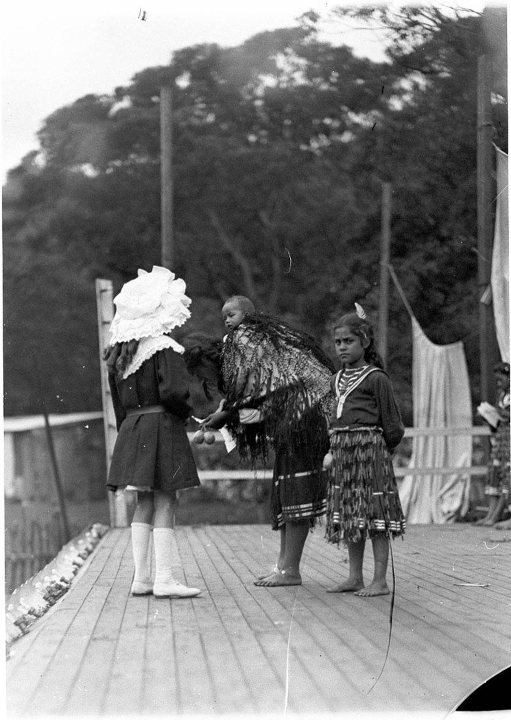 Maori mother and children with girl in European dress, Maori village, Clontarf, ca. 1910, by AJ Perier, c. 1910