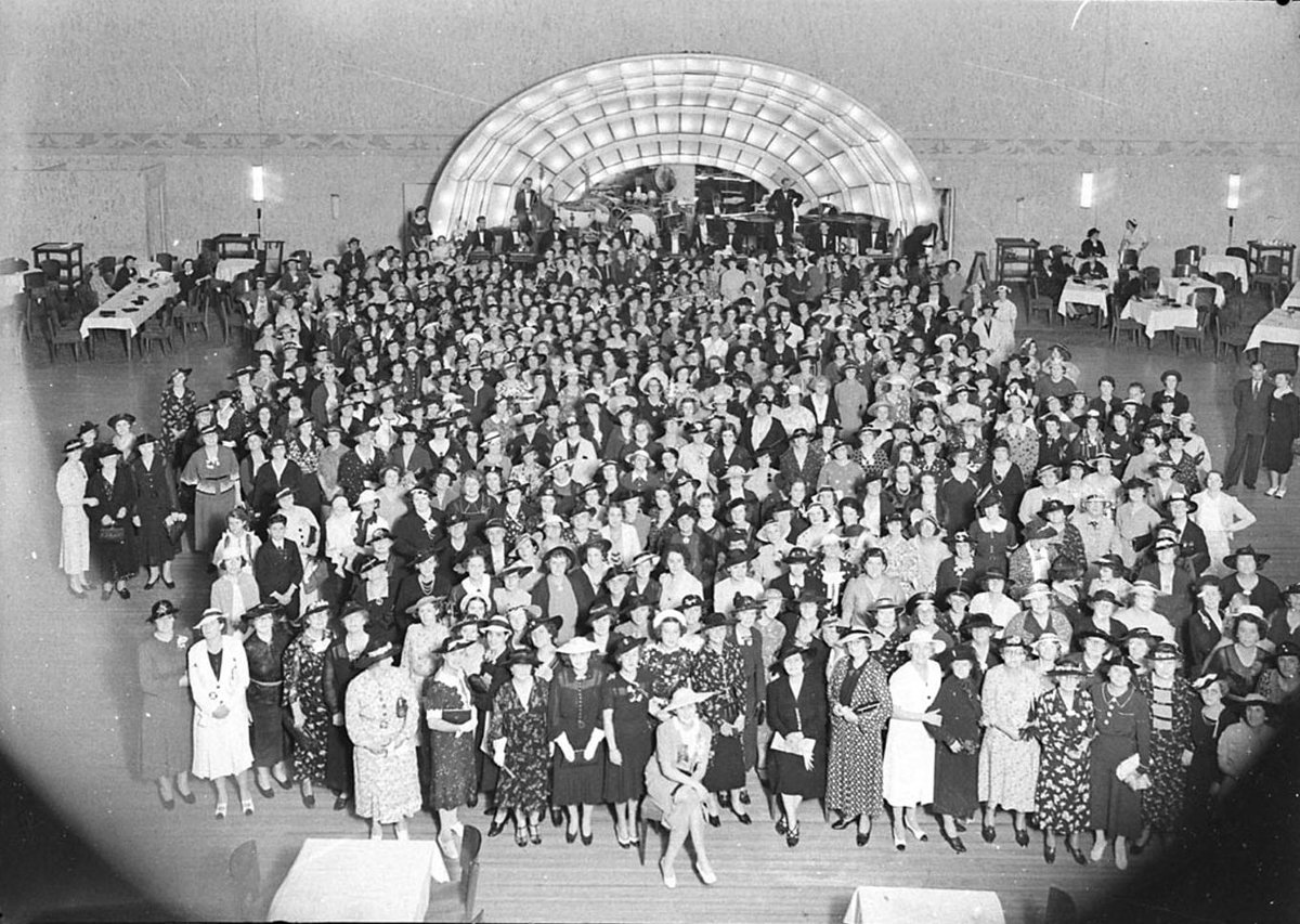 A flash-powder photograph of a large party of women in front of bandstand at a 2CH party at the Trocadero, 15 December 1937, Sydney