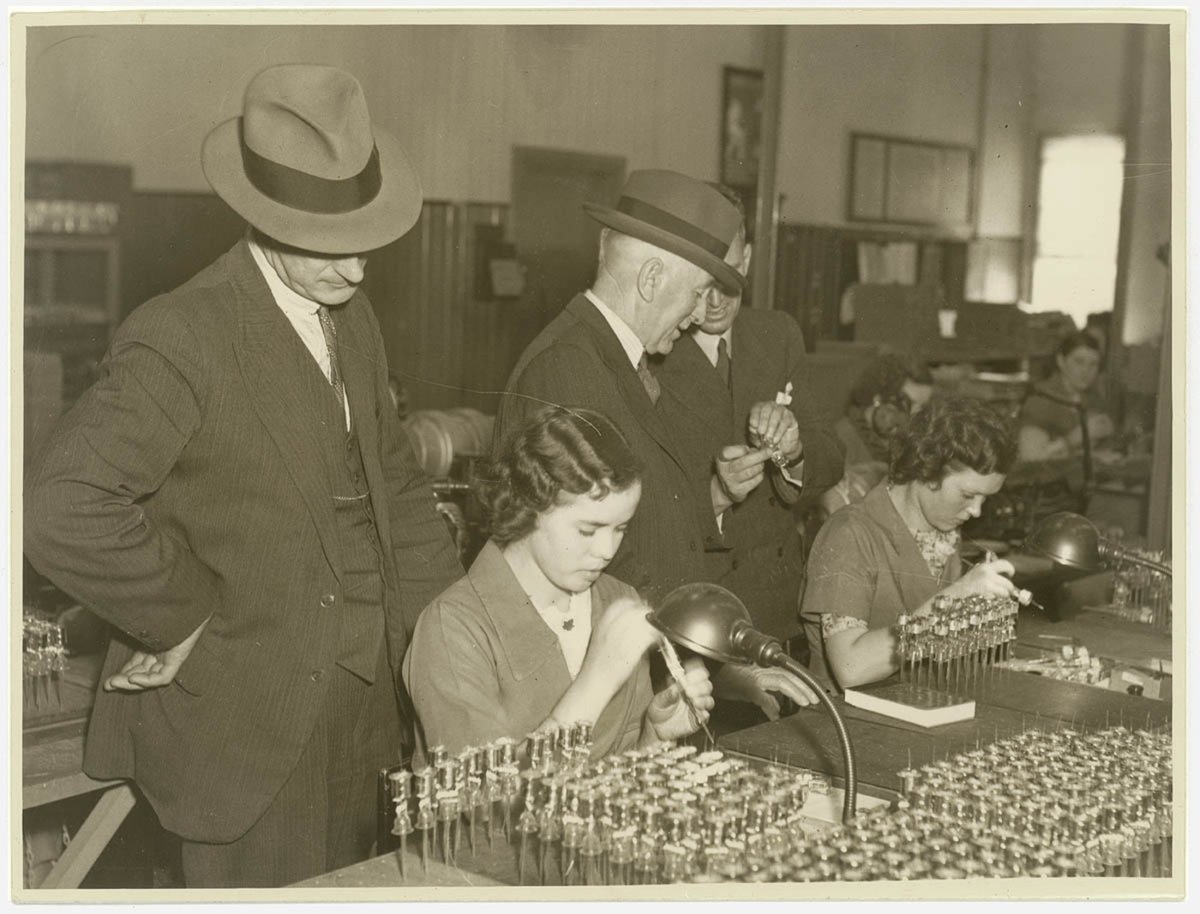 Executives watch women AWA factory workers making radio valves, 1936, by Sam Hood, Ashfield