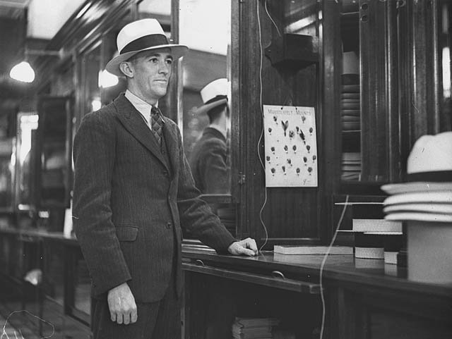 Photographer Lethington Maitland in a new panama from City Hatters in Pitt Street, during Panama and Straw Hat Week, 1 November 1934, by Ernie Bowen, Sydney city centre