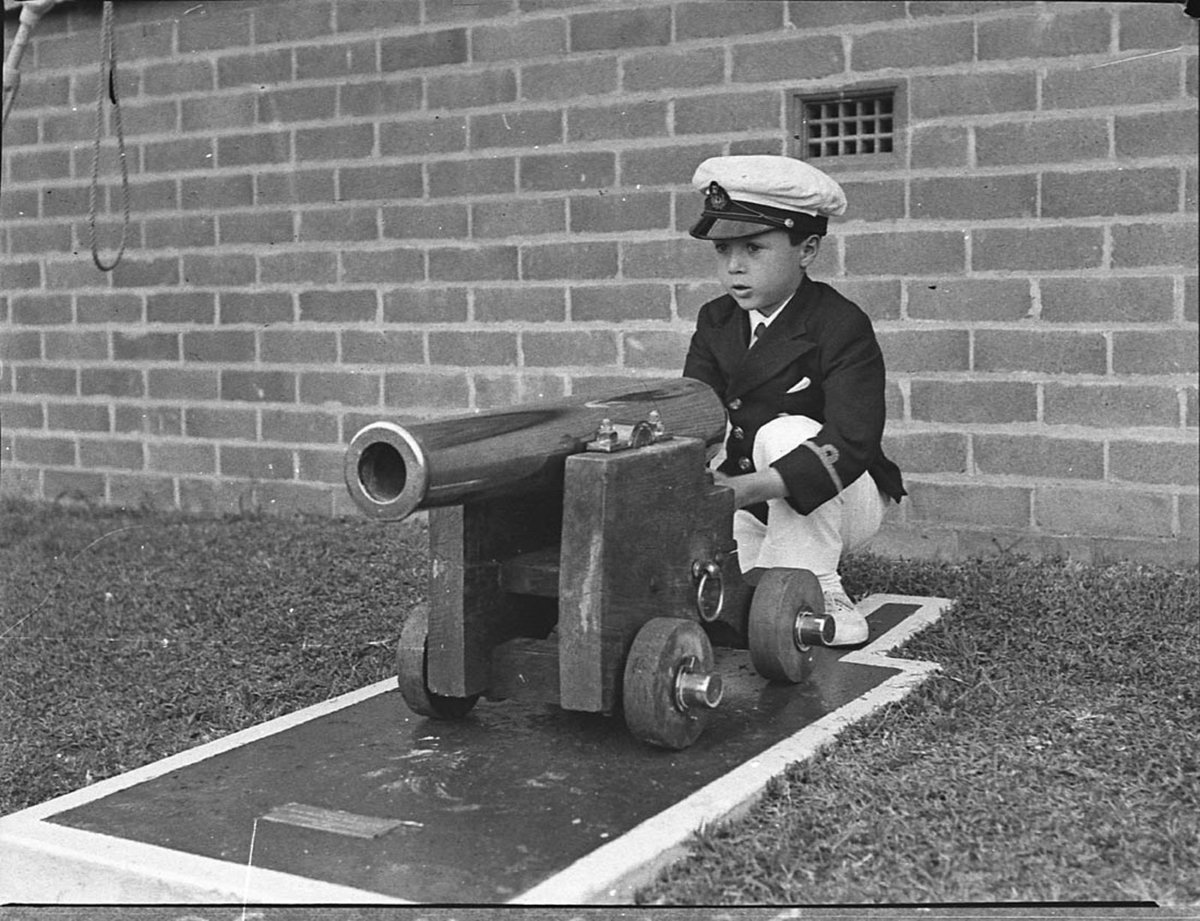 Boris Neville plays with the cannon in front of the new clubhouse at the Royal Motor Yacht Club of NSW, Rose Bay, Sydney, at the start of the motor boat season, 19 September 1936 - Sam Hood