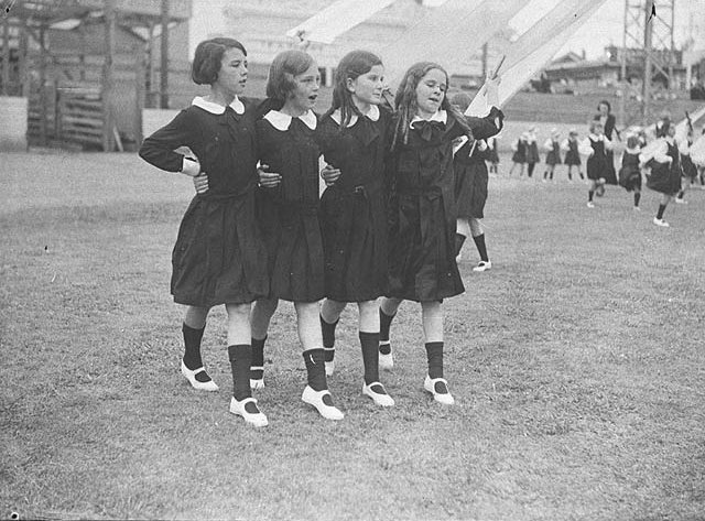 Group of four young schoolgirls singing as they dance round the maypole , 1935 - Sam Hood, Moore Park