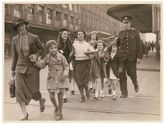 Policeman helps woman with group of girls to cross a city street, ca. 1935, from Hood Collection part II - (Children in groups and with adults, social functions, etc.), ca. 1925-ca. 1955 - Sam Hood, Sydney (1925–55)