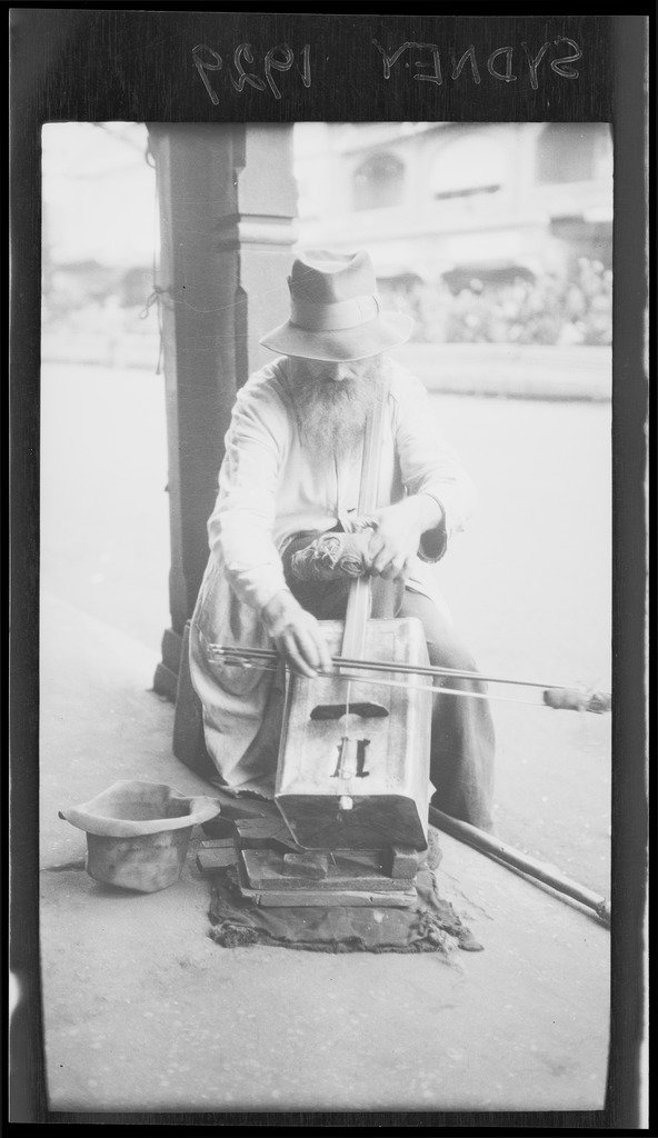 Man busking with a one-string fiddle made from a kerosene tin, Sydney, 1929
