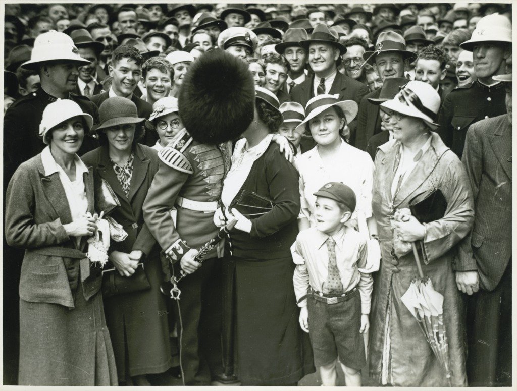 A member of the Band of His Majesty's Grenadier Guards kissing a person in crowd in Martin Place, Sydney after a ceremony at the Cenotaph, 8 November 1934