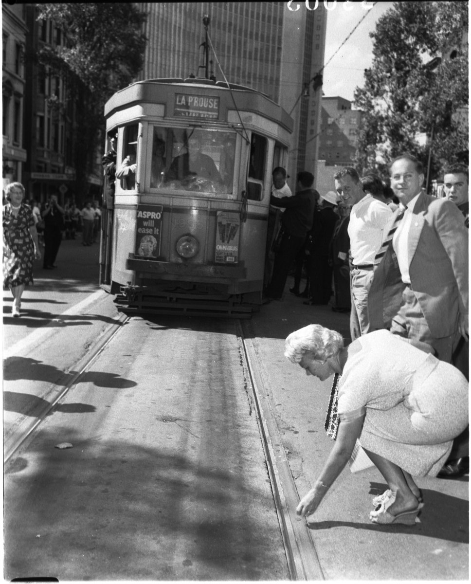 Woman puts coin on the rails on last (?) day of trams, Sydney, 26 February 1961 - unknown photographer